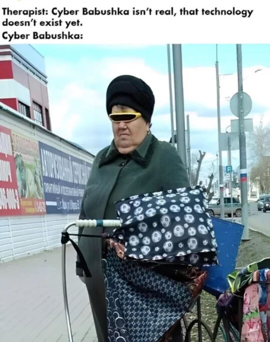 This meme is a humorous commentary on the concept of "cyber" or "cyber"babushka, a term that refers to a stereotypical, elderly Russian woman who is somehow connected to the internet. The text at the top of the image reads, "Therapist: Cyber Babushka isn't real, that technology doesn't exist yet. Cyber Babushka: I am real, I am online, I am watching you." The image itself depicts an elderly woman, dressed in a traditional Russian outfit, wearing a dark coat, hat, and sunglasses, with a determined expression.
